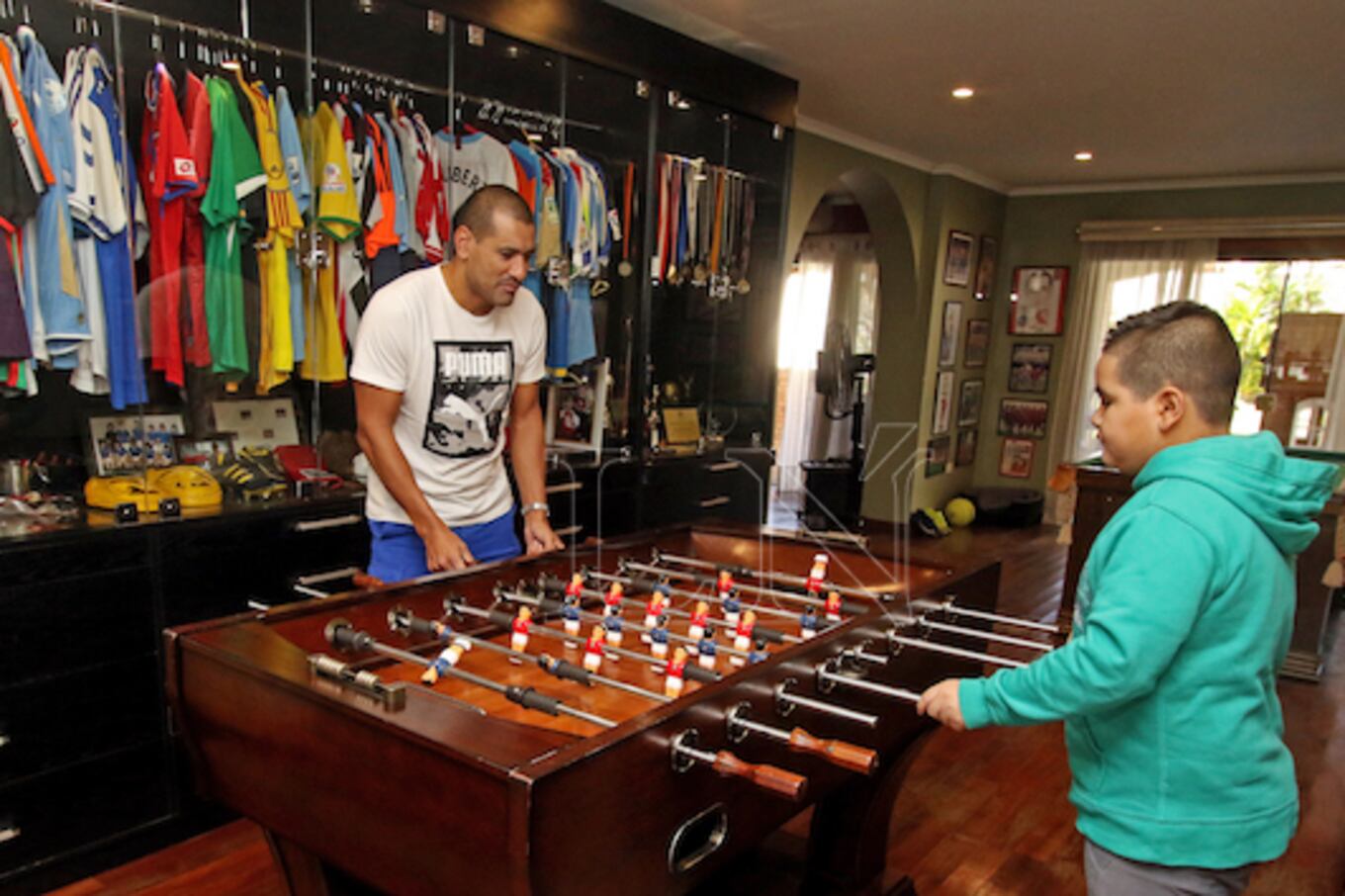 Un ameno partido de futbolito con su hijo Lucas, luciendo en el fondo la colección de camisetas.FOTO:NÉSTOR SOTO