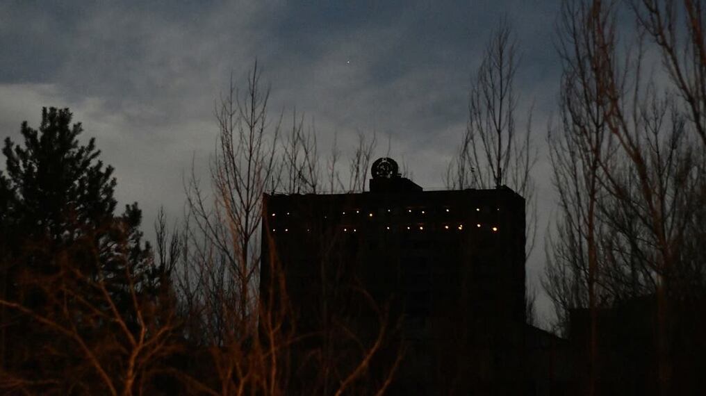 Luces prendidas en un edificio abandonado de la ciudad fantasma de Prípiat, donde se encuentra ubicada la central nuclear de Chernóbil. Foto: AFP.