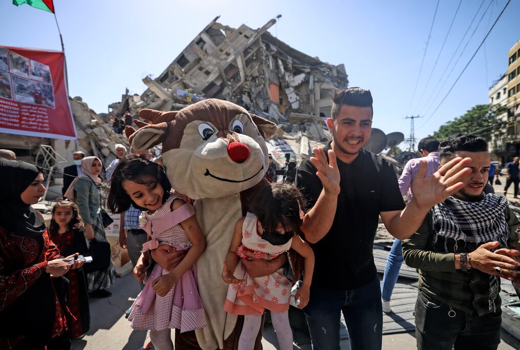 Palestinos con disfraces inspirados en dibujos animados entretienen a los niños sobre los escombros de la torre al-Shourouk, en la ciudad de Gaza. Foto: AFP.