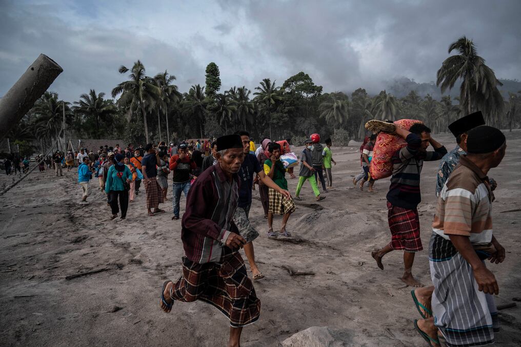 Los aldeanos rescatan sus pertenencias en un área cubierta de ceniza volcánica en la aldea de Sumber Wuluh en Lumajang. Foto: AFP.