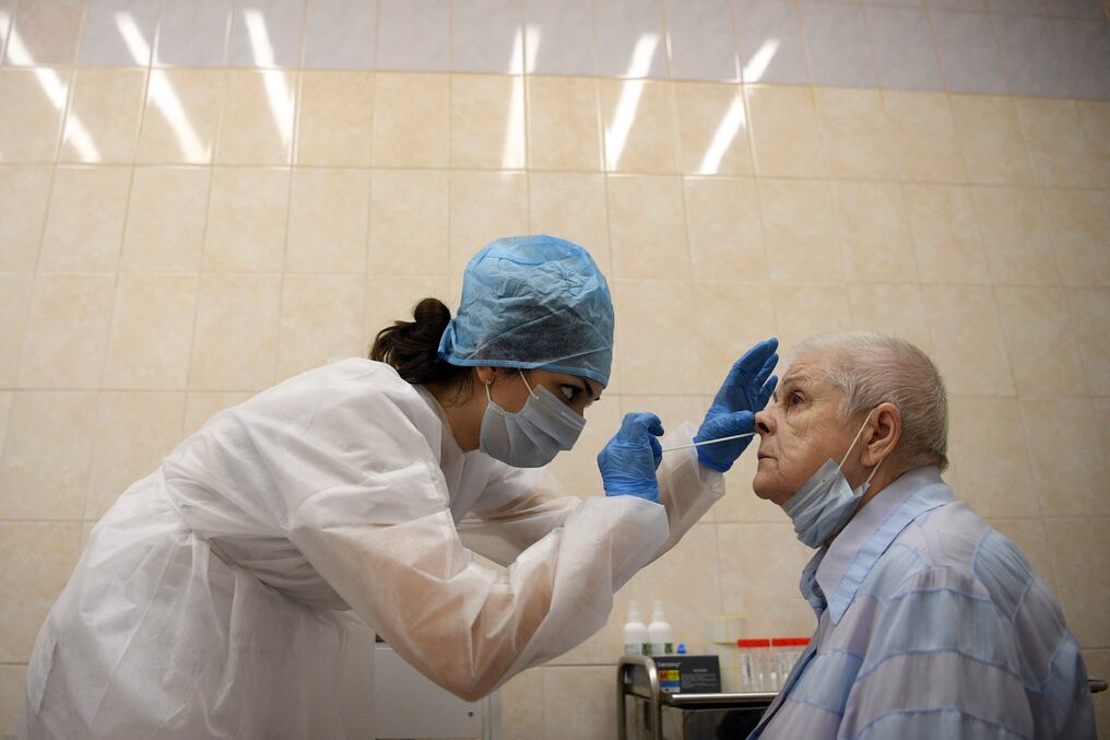 Un trabajador médico toma un hisopo de una mujer en un centro médico en Moscú el 16 de julio de 2020. Foto: AFP.