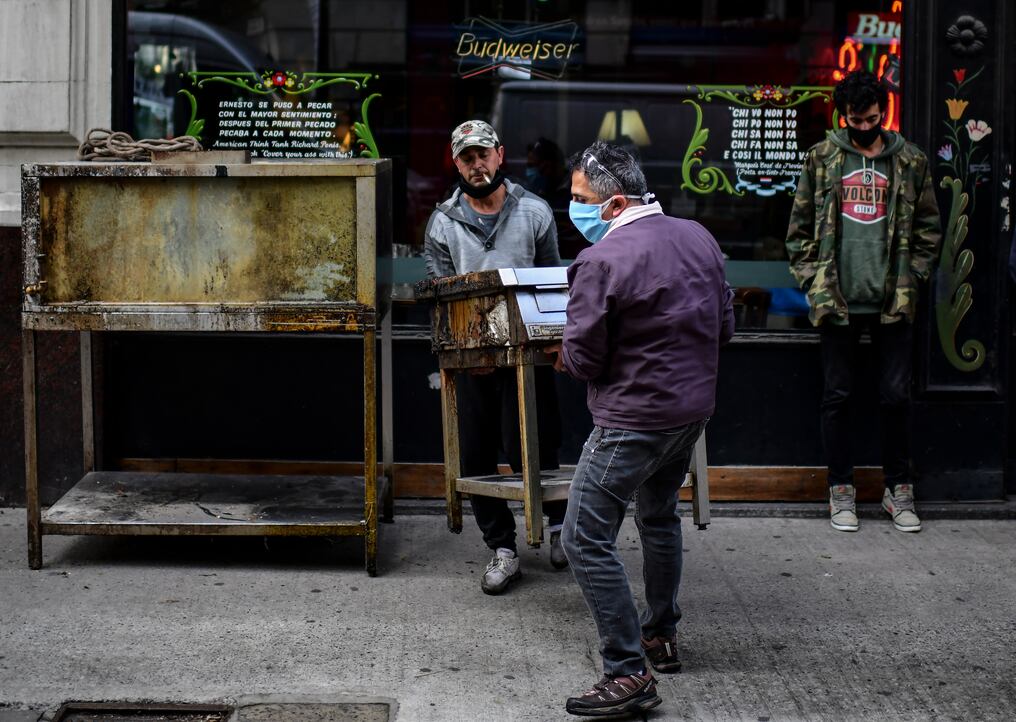 Los trabajadores llevan una estufa fuera del restaurante cerrado La Tekla en Buenos Aires. Foto: AFP.