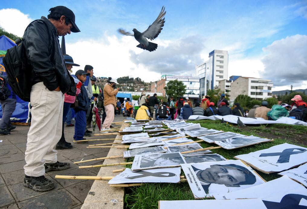Un hombre mira fotos de civiles que murieron durante las manifestaciones a nivel nacional contra la presidenta Dina Boluarte en la plaza Túpac Amaru en Cusco. Foto: AFP.