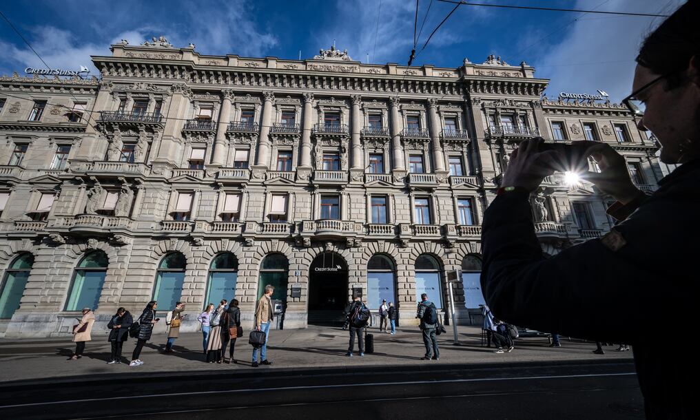 Un hombre toma una foto de la sede de Credit Suisse después de que el gigante bancario suizo UBS acordó hacerse cargo de su rival suizo. Foto: AFP.