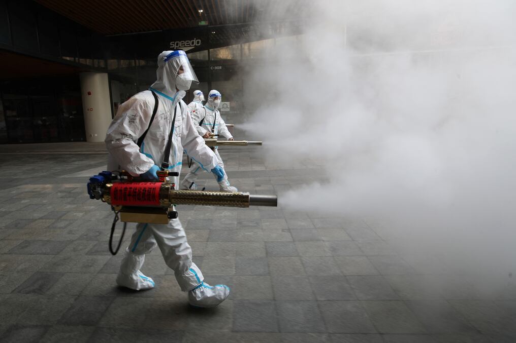 Las dudas sobre la efectividad de esta estrategia no amilanan a los "dabai", que en chino significa "grandes blancos", como se denomina a los empleados que realizan esta tarea de limpieza, cuyos trajes de protección son blancos. Foto: AFP