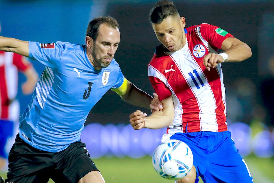 El defensor uruguayo Diego Godín, en pleno uso de su oficio, empuja con el brazo al paraguayo Ángel Romero.FOTO:AFP