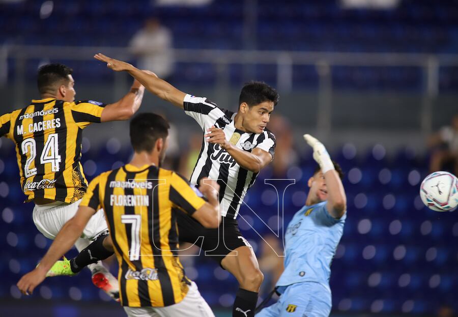 Lorenzo Melgarejo le gana en el salto a José Florentín, Marcos Cáceres y al arquero Gaspar Servio. La acción concluyó en el gol, el primero que abrió el partido a favor de Libertad.FOTO:JORGE ROMERO