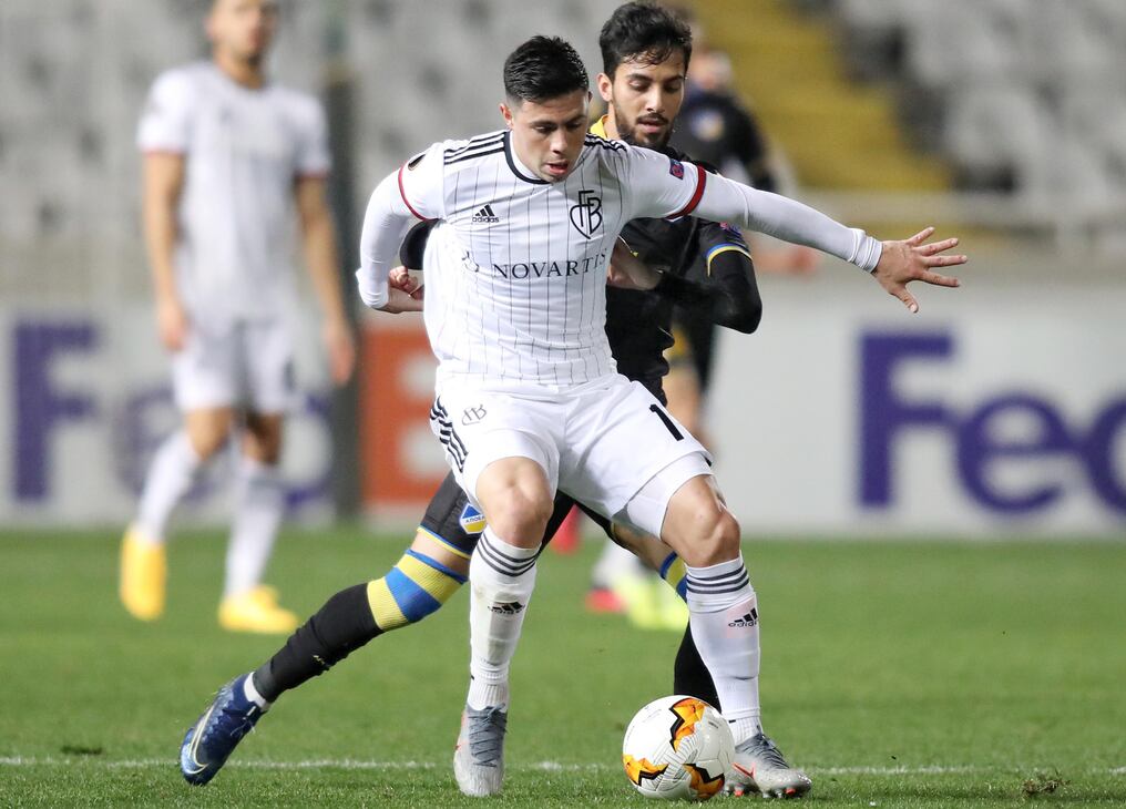 El defensor paraguayo Blas Riveros del Basilea protege el balón ante la presión de Musa Suliman de Apoel Nicosia, durante el partido de Europa League.
