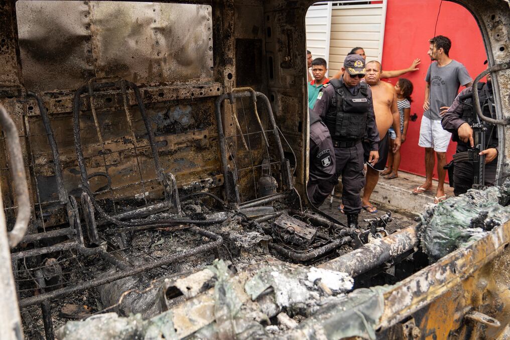 Un policía hace guardia junto a un camión comercial incendiado por pandilleros en Natal, en el estado de Rio Grande do Norte. Foto: AFP.