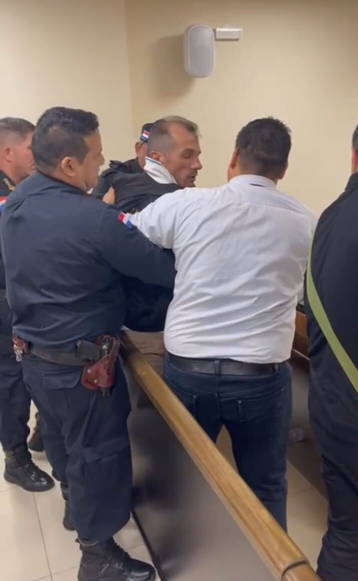 El ciudadano brasileño Plácido Caetano Magrin, siendo atajado por policías y funcionarios judiciales, tras intentar agredir al fiscal Elvio Aguilera, al término del juicio oral que le condenó a 12 años de prisión por tráfico de drogas. FOTO: Gentileza (Captura de vídeo)