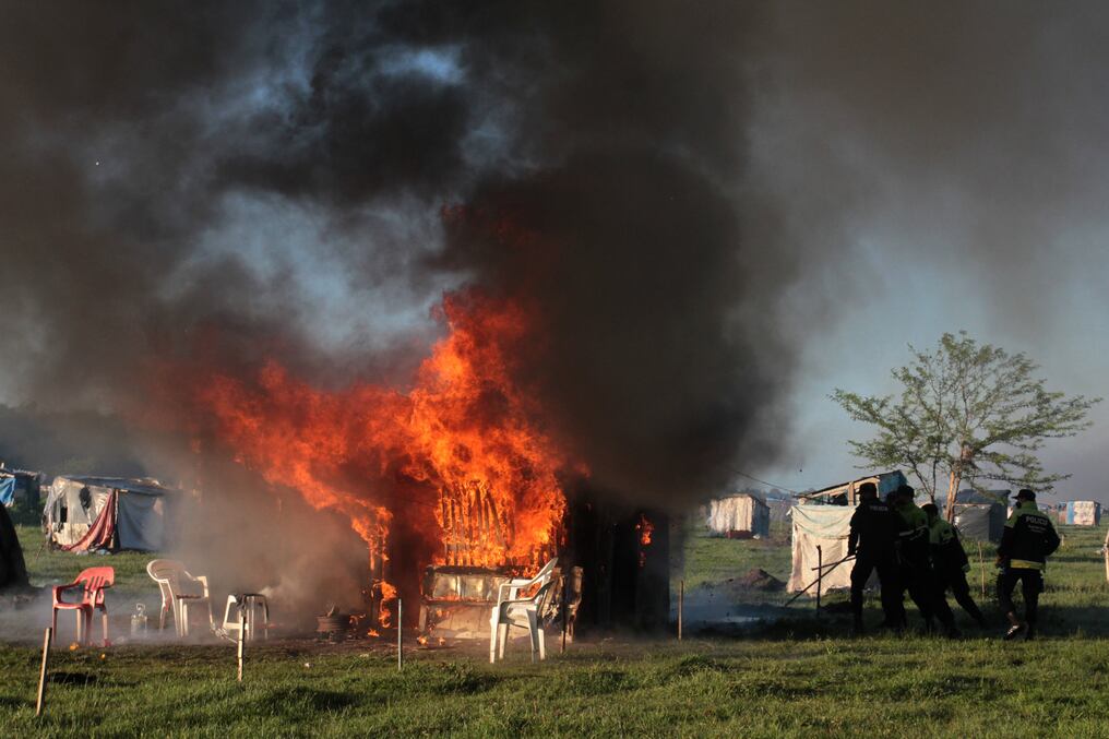 Unos 4.000 policías ingresaron la madrugada del jueves al lugar y derribaron las casillas, míseros refugios de palos y plásticos que ardieron en fogatas en medio de escenas de pánico y furia. Foto: AFP.
