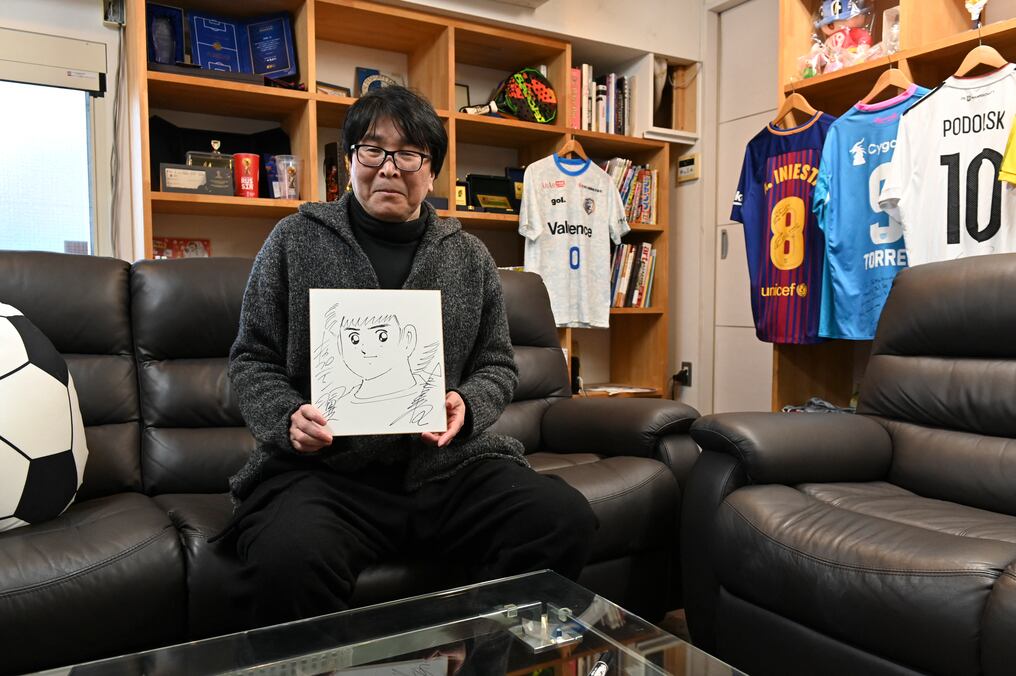 El caricaturista japonés Yoichi Takahashi muestra su autógrafo con la imagen del personaje principal en su lugar de trabajo en Tokio. Foto: AFP.