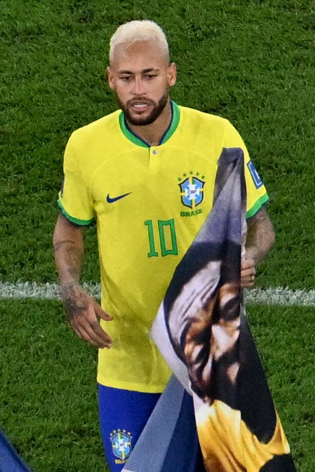 El delantero brasileño sostiene una pancarta dedicada a la leyenda del fútbol brasileño Pelé al final del partido de octavos contra Corea del Sur. Foto: AFP.