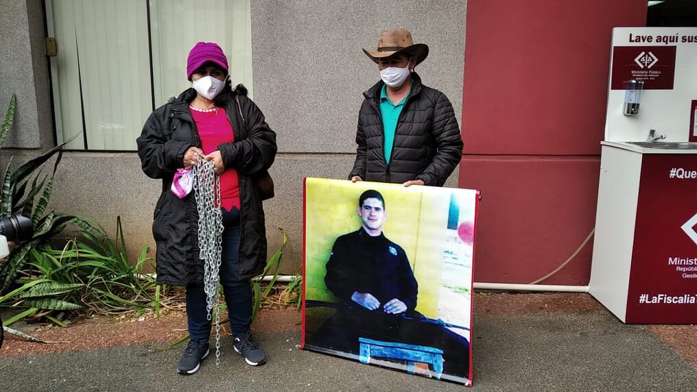 Obdulia Florenciano y Apolonio Morínigo, padres de Edelio, portan una fotografía de su hijo a su llegada a la sede central de la Fiscalía en Asunción. Foto: 1020 AM.