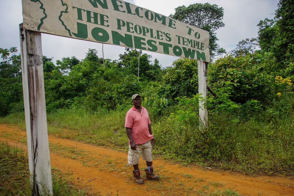 Fitz Duke posa en la entrada del asentamiento en lo profundo de la jungla donde más de 900 personas murieron el 18 de noviembre de 1978. Foto: AFP.