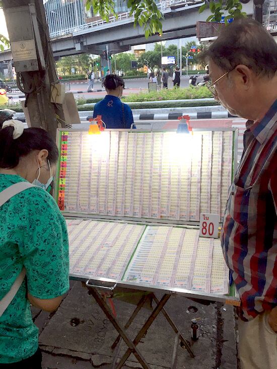Un hombre vende billetes de lotería frente a un templo en Bangkok. La lotería estatal es el único juego de azar permitido en Tailandia.FOTO:DOW KAEWJINDA/DPA