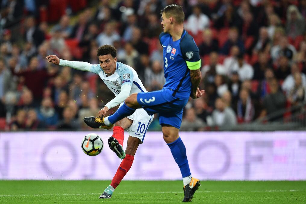 el volante inglés Dele Alli busca el gol con fuerte remate ante la oposición del zaguero eslovaco Martin Skrtel. AFP